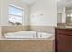 Corner soaking tub with tile surround in a bright bathroom at 1893 Rafton Rd, Apopka, FL 32703