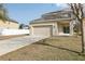 Beige two-story home featuring a two-car garage, a simple front yard and a concrete driveway at 1893 Rafton Rd, Apopka, FL 32703