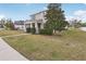 Attractive two-story home with a covered front porch, lush lawn, and mature tree at 1893 Rafton Rd, Apopka, FL 32703