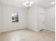 Light-filled living room featuring tile flooring, a window, and a modern chandelier at 1893 Rafton Rd, Apopka, FL 32703