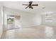 Spacious living room with neutral tile flooring, ceiling fan, and sliding door to the outside at 1893 Rafton Rd, Apopka, FL 32703