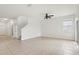 Spacious living room with tile flooring, a ceiling fan, and access to the staircase at 1893 Rafton Rd, Apopka, FL 32703