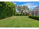 Lush backyard features manicured lawn, mature trees, and a screened-in lanai, perfect for outdoor enjoyment at 2008 Water Key Dr, Windermere, FL 34786