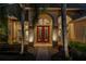 Elegant home featuring a red double door entrance, complemented by lush landscaping and warm exterior lighting at 2008 Water Key Dr, Windermere, FL 34786