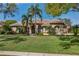 Expansive one-story home showing lush green lawn, two large palm trees, neutral stucco and tile roof at 2008 Water Key Dr, Windermere, FL 34786