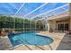Screened in pool area with travertine tile, waterfall feature, patio seating and well-manicured landscaping at 2008 Water Key Dr, Windermere, FL 34786