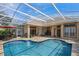 Screened-in pool area with travertine tile, waterfall feature, patio seating, and immaculate landscaping at 2008 Water Key Dr, Windermere, FL 34786