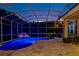 Beautiful screened-in pool area with stone tile deck, waterfall, and outdoor seating at dusk at 2008 Water Key Dr, Windermere, FL 34786