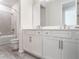 Bathroom showcasing a double vanity with white cabinetry, quartz countertop, and a shower-tub combo at 2189 Weatherly Way, Orlando, FL 32820