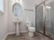 Bright bathroom featuring wood-look flooring, pedestal sink, and glass-enclosed tiled shower at 2189 Weatherly Way, Orlando, FL 32820