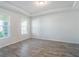 Bright, empty bedroom with tray ceiling, wood-look tile, and two windows at 2189 Weatherly Way, Orlando, FL 32820