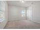 Well-lit bedroom with a large window, soft neutral carpeting, and a white door at 2189 Weatherly Way, Orlando, FL 32820