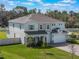 Exterior home shot showcases a well-manicured lawn, long driveway, and fenced in yard at 2189 Weatherly Way, Orlando, FL 32820