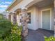Inviting front porch with stone columns and a light blue front door at 2189 Weatherly Way, Orlando, FL 32820