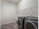 Modern laundry room equipped with front-load washer and dryer and tiled floors at 2189 Weatherly Way, Orlando, FL 32820
