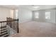 Spacious loft area with plush carpet and a staircase featuring a decorative iron railing at 2189 Weatherly Way, Orlando, FL 32820