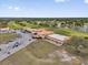 An aerial view of the golf course and resort featuring a restaurant, driving range, and clubhouse at 2430 Park Ave, Indian Lake Estates, FL 33855