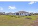 The home features a fenced backyard, green lawn, and landscaping at 2430 Park Ave, Indian Lake Estates, FL 33855