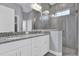 Modern bathroom showcasing double vanity sinks, granite counters, and glass-enclosed shower at 2430 Park Ave, Indian Lake Estates, FL 33855