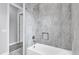 The bathroom features gray tiled walls, a shower with a shower head, and a built-in soap niche at 2430 Park Ave, Indian Lake Estates, FL 33855