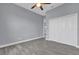 Bedroom featuring gray wood-look tile, a fan, and closet with white bi-fold doors at 2430 Park Ave, Indian Lake Estates, FL 33855