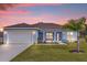 Beautiful single-story home with a well-manicured lawn and a palm tree in the front yard at 2430 Park Ave, Indian Lake Estates, FL 33855