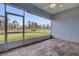 A screened-in patio offers a view of the backyard and the surrounding natural landscape at 2430 Park Ave, Indian Lake Estates, FL 33855