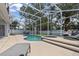 Screened pool area complete with a spa, outdoor seating, and sun loungers for relaxing by the water at 2560 Sand Hill Point Cir, Davenport, FL 33837