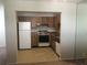 Kitchen features a white fridge, oven, dishwasher, and wood cabinets at 2597 Oak Park Way # 205, Orlando, FL 32822