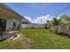 Expansive backyard featuring a well-manicured lawn, privacy fence, and a covered patio at 2817 Noble Crow Dr, Kissimmee, FL 34744