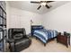 Comfortable bedroom featuring neutral walls, fan, chair, and a well-organized display shelf at 2817 Noble Crow Dr, Kissimmee, FL 34744