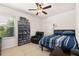 Well-lit bedroom with a ceiling fan, closet, and a cozy setup with a bed, chair, and entertainment center at 2817 Noble Crow Dr, Kissimmee, FL 34744