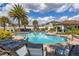 Relaxing community pool with palm trees, lounge chairs, and a covered outdoor seating area at 2817 Noble Crow Dr, Kissimmee, FL 34744
