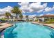 Stunning community pool with inviting lounge chairs, palm trees, and a nearby covered pavilion at 2817 Noble Crow Dr, Kissimmee, FL 34744