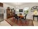 Open dining room with a wood table, four chairs, and a display cabinet, bathed in natural light from the windows at 2817 Noble Crow Dr, Kissimmee, FL 34744