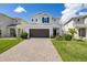 Charming two-story home with brick driveway, attached two-car garage, manicured lawn and neutral-toned exterior at 2817 Noble Crow Dr, Kissimmee, FL 34744