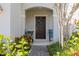 Inviting front porch with decorative chairs, a wreath on the door, and lush landscaping at 2817 Noble Crow Dr, Kissimmee, FL 34744