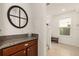 Hallway featuring a half bath area with granite counters and wooden cabinetry at 2817 Noble Crow Dr, Kissimmee, FL 34744