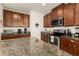 Spacious kitchen featuring granite countertops, stainless steel appliances, and dark wood cabinets at 2817 Noble Crow Dr, Kissimmee, FL 34744