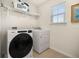 Modern laundry room equipped with a new washer, dryer, and convenient shelving at 2817 Noble Crow Dr, Kissimmee, FL 34744