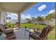 Inviting covered patio with cushioned chairs and a view of the manicured backyard at 2817 Noble Crow Dr, Kissimmee, FL 34744