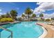 Community pool surrounded by chairs and lush greenery at 2817 Noble Crow Dr, Kissimmee, FL 34744