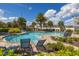 Community pool surrounded by chairs and lush greenery at 2817 Noble Crow Dr, Kissimmee, FL 34744