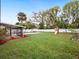 Expansive backyard features playset, screened lanai, pool area, mature trees, and white fence at 2900 E Grant Ave, Orlando, FL 32806