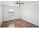 Bright bedroom showcasing wood-look flooring, white walls, ceiling fan, and natural light at 2900 E Grant Ave, Orlando, FL 32806