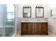 Bathroom features double sink vanity, shower with glass door, large mirrors, modern lighting, and decorative tile details at 3006 Mandolin Dr, Kissimmee, FL 34744