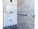 Close up of renovated shower with glass tile accents, new rain head and shower seat at 3006 Mandolin Dr, Kissimmee, FL 34744