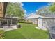 Well-maintained backyard with green grass, a patio set, an outdoor grill, a shed, and a wooden fence at 344 Sandpiper Dr, Casselberry, FL 32707