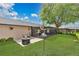 Scenic backyard view with lush green grass, a patio set, an outdoor fire pit, and a wooden fence at 344 Sandpiper Dr, Casselberry, FL 32707