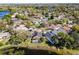 Aerial shot of a home with a screened-in pool and lake access surrounded by lush greenery at 352 Misty Oaks Run, Casselberry, FL 32707